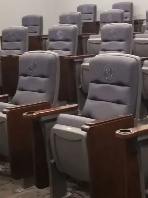A row of grey seats in an auditorium.