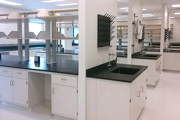 A clean lab with black counter tops and white cabinets.
